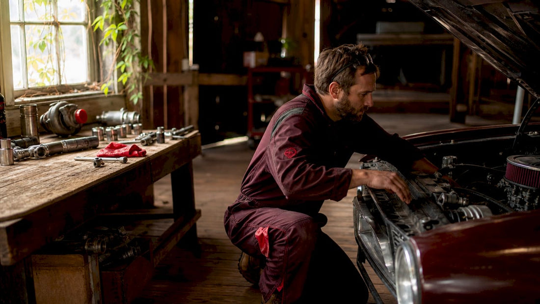Technician inspecting car engine in garage