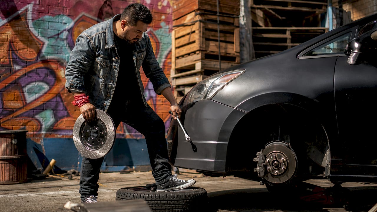 Man inspecting car brake rotor outdoors