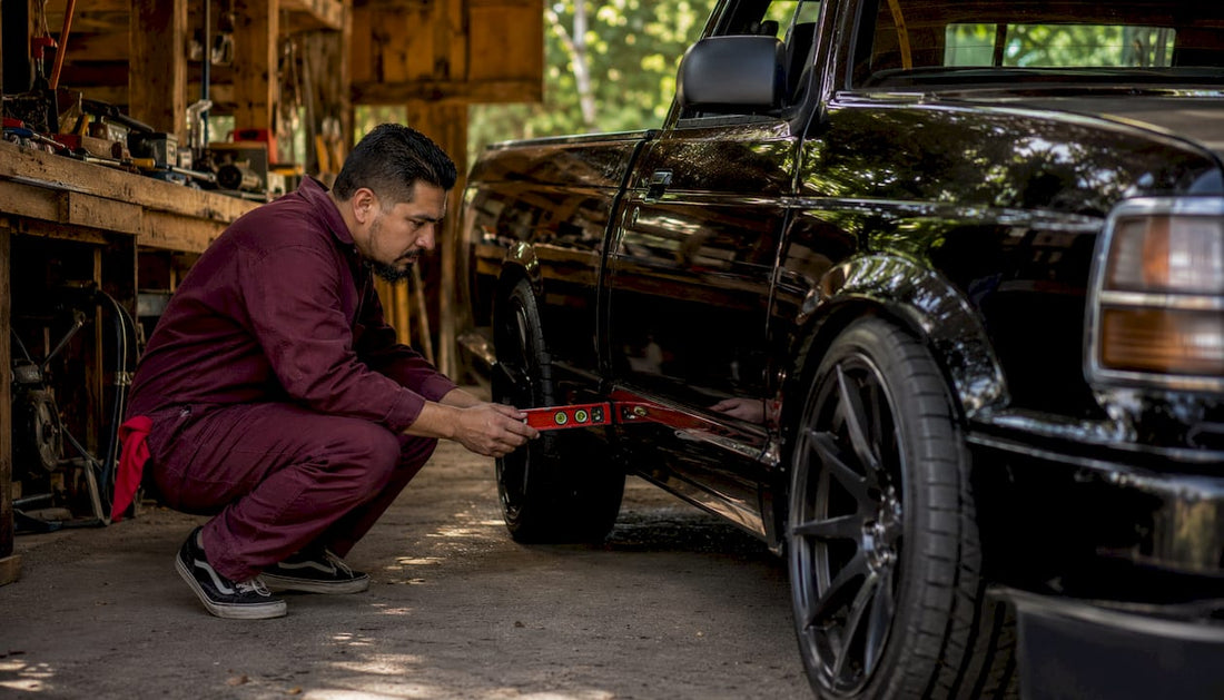 Mechanic inspecting lowered pickup truck stance