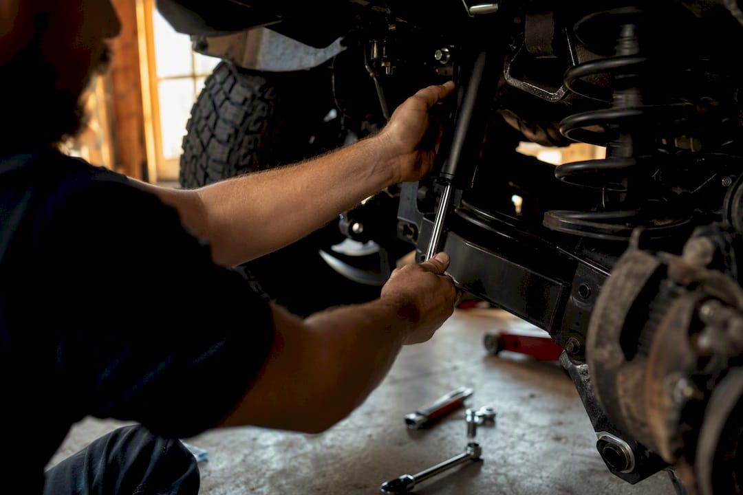 Hands installing monotube shock on truck suspension