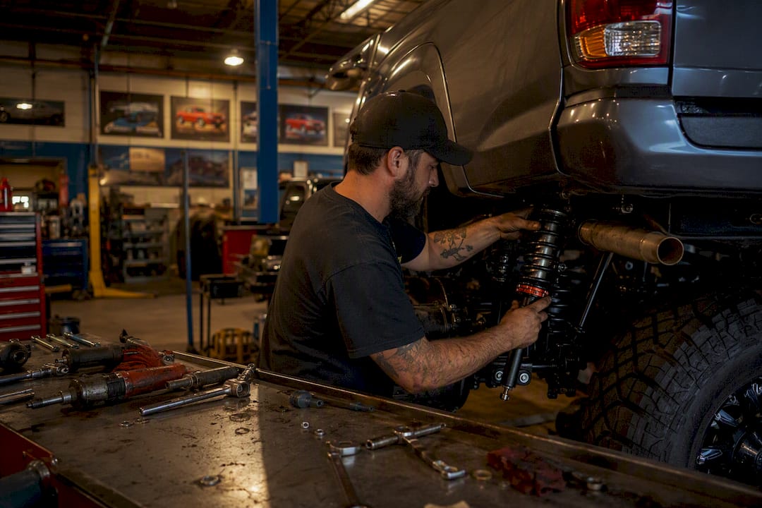 Hands installing coilover on Tacoma suspension