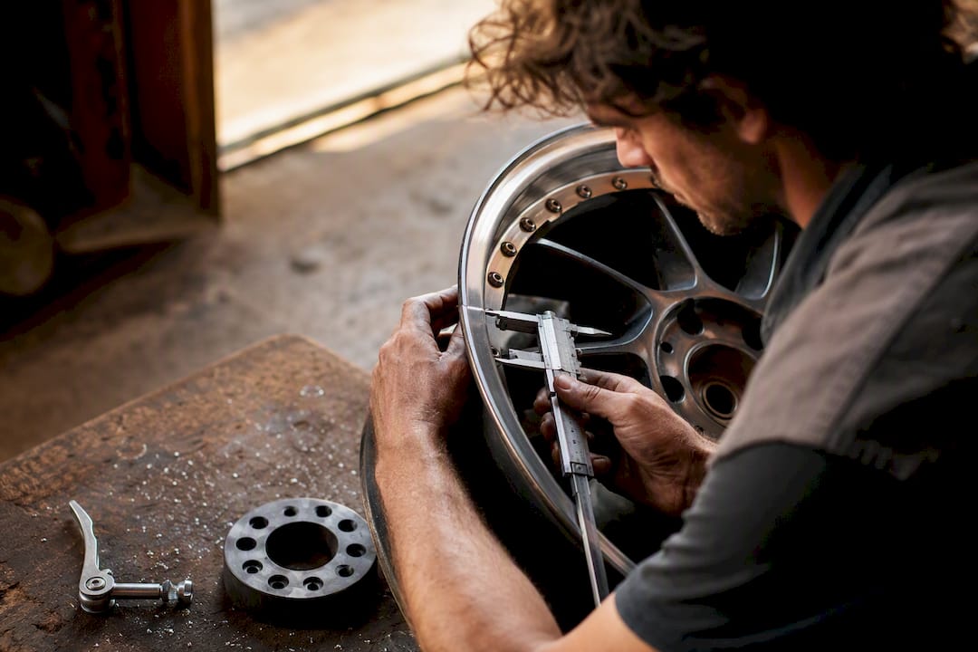 Hands measuring wheel offset on rim