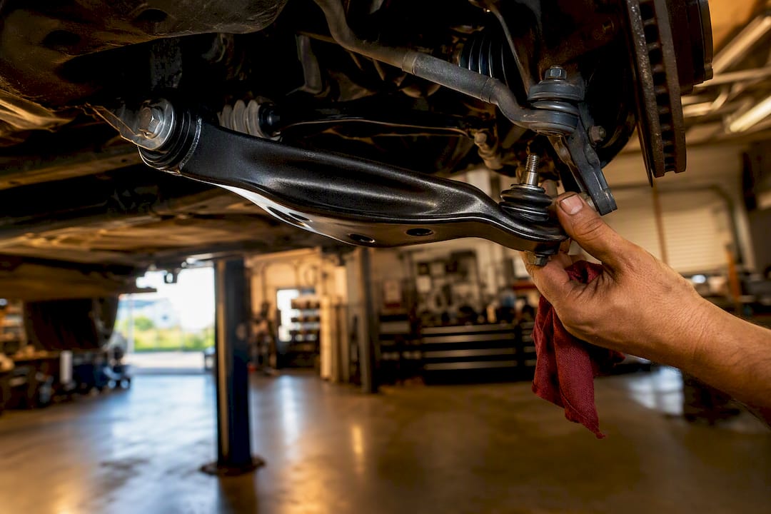 Anonymous control arm inspected under vehicle